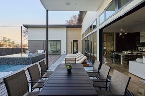 Zona d'estar a l'aire lliure i moderna amb piscina, seients i vistes a la ciutat.