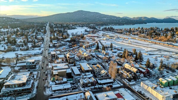 An aerial view of a snowy town with a train station, roads, and buildings. - The Silver Buffalo Suite in Downtown Whitefish (Whitefish)