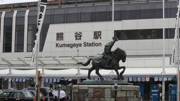A statue of a man on a horse in front of Kumagaya Station.