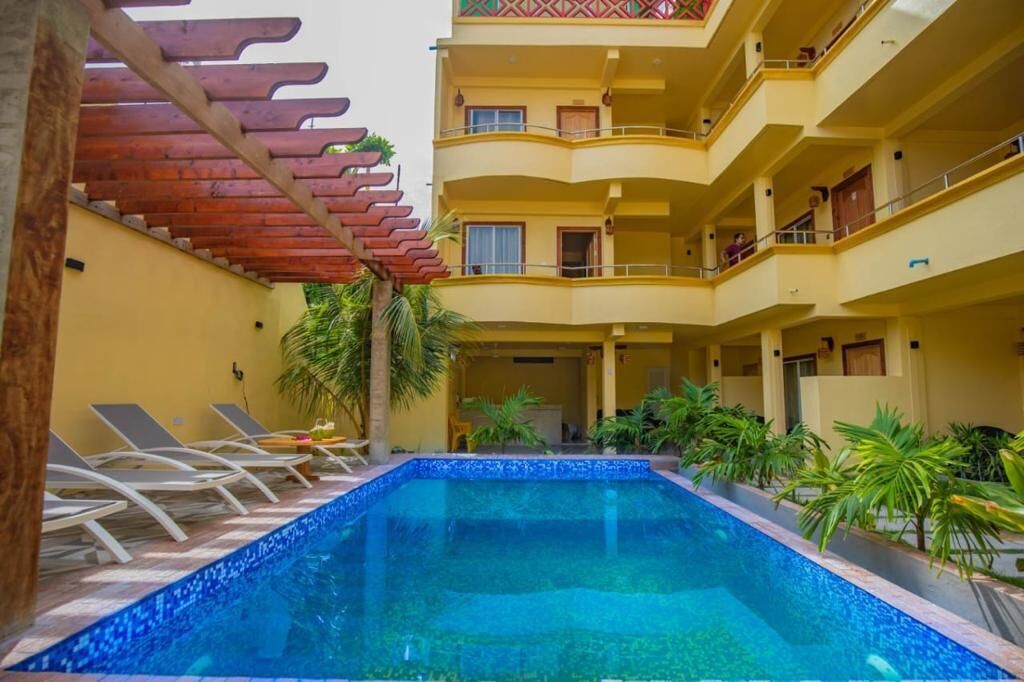 A multi-story hotel with a central swimming pool, balconies, and outdoor seating.