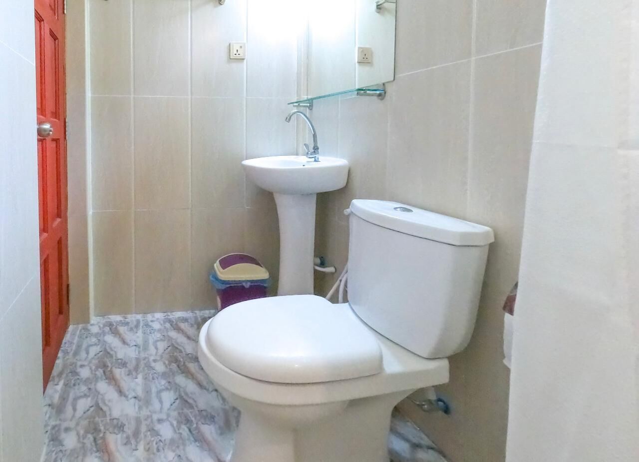 Ein kleines Badezimmer mit Toilette, Waschtisch und einem Spiegel darüber.