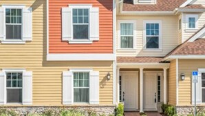 A row of townhouses with a uniform architectural style, featuring gabled roofs and white shutters. - Amazing home in Orlando just 5 minute away from Disney World (Kissimmee)