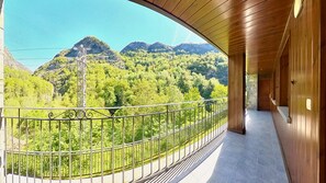 A balcony with a view of a forested mountain range.
