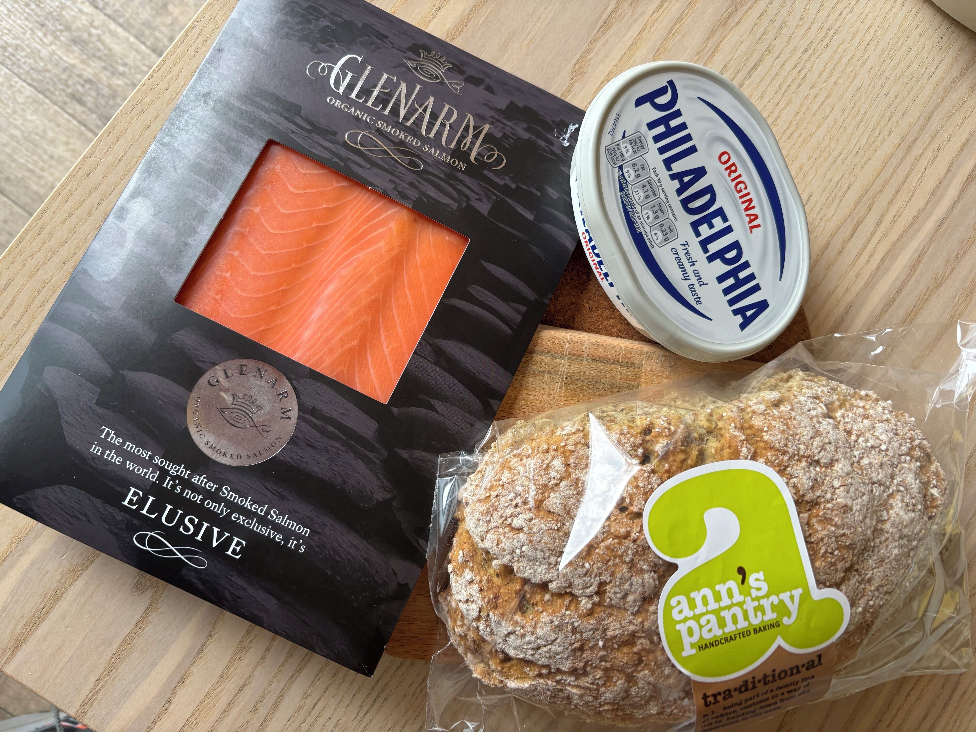 A package of Glenarm Organic Smoked Salmon, a container of Philadelphia cream cheese, and a loaf of bread from Ann's Pantry.