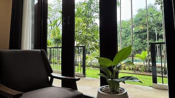 Habitación de lujo doble, patio, vistas a la piscina | Zona de estar | Televisión LED de 40 pulgadas con canales digitales