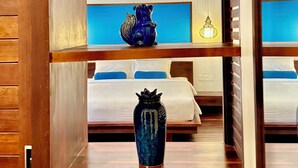 Ein Regal aus Holz mit Dekorationen und ein Bett im Hintergrund.