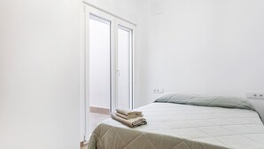 Una camera da letto con un letto, una porta e una presa elettrica.