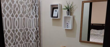 A bathroom with a toilet, bidet, sink, and a shower curtain.