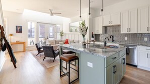 A spacious kitchen with a large island, white cabinetry, and a modern design.
