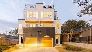 A modern two-story house with a large garage and a covered driveway.
