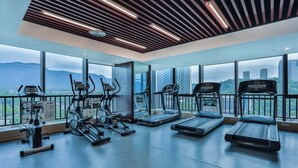 Una palestra con tapis roulant, cyclette ed ellittiche, ampie finestre con vista sulla città e sulle montagne.