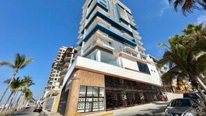 A multi-story hotel with a modern design, featuring balconies and large windows. - Boca de cielo Apartments (Mazatlán)