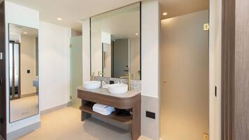 A modern bathroom with two sinks, a large mirror, and a wooden vanity.