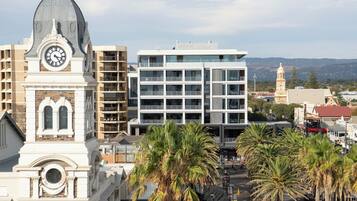 Un campanar amb cúpula, edificis moderns i palmeres en un paisatge urbà.