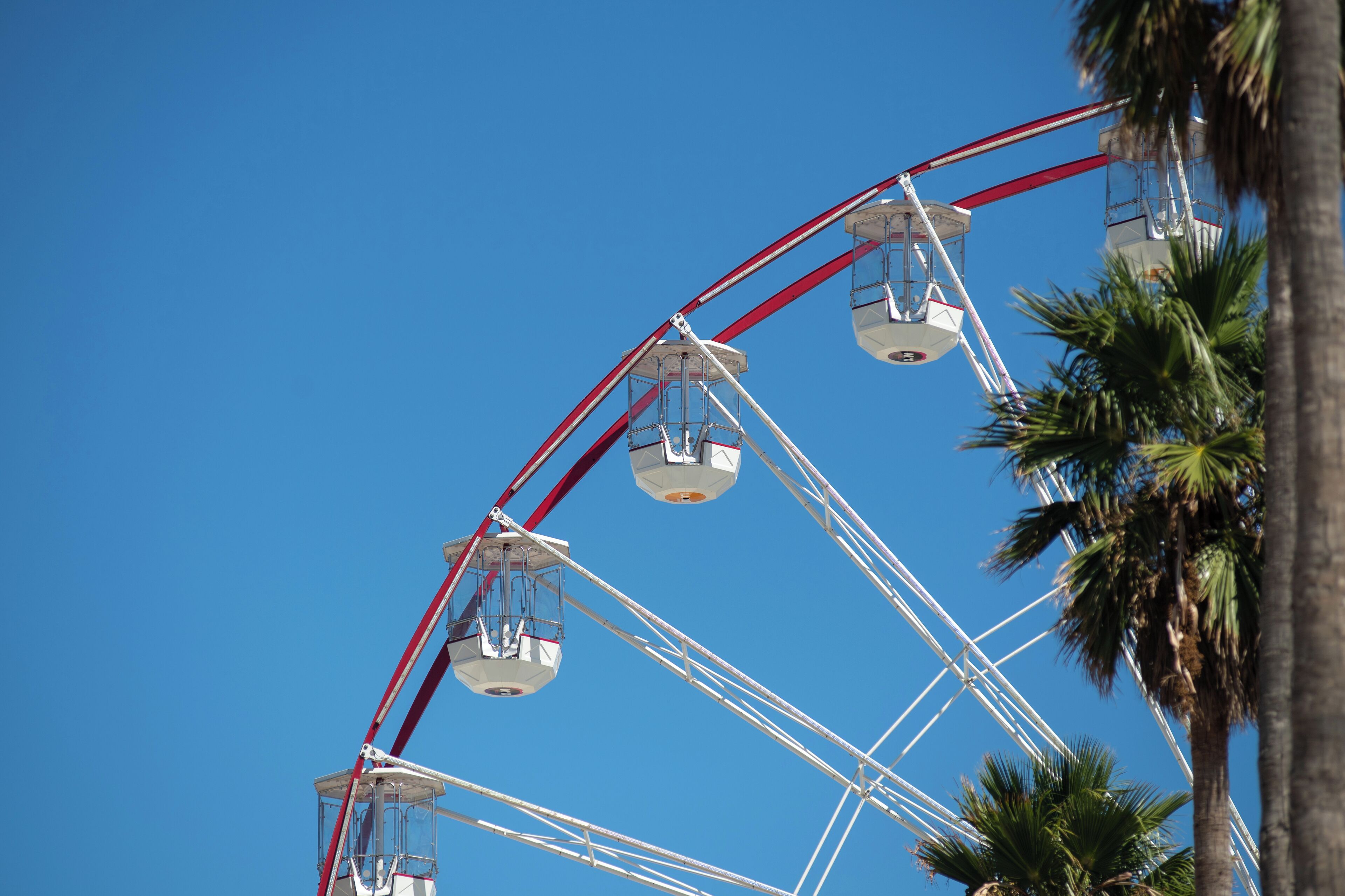 Une grande roue avec des cabines, se dressant devant un ciel bleu dégagé.