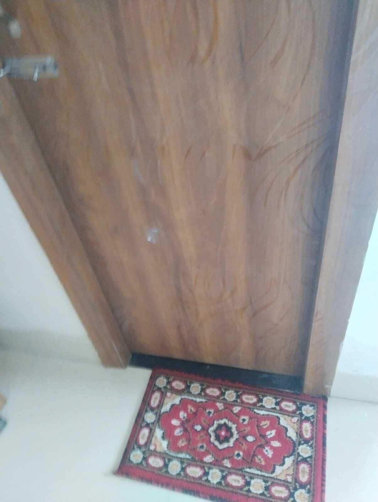 A wooden door with a patterned rug at its base.