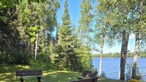Järvenrantapuisto, jossa on puinen penkki, betoninen penkki ja nuotiopaikka.