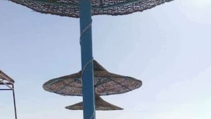 A rooftop terrace with artificial grass, a blue pole, and a circular structure with a net-like roof. - Sekhmatone 1-bedroom apartment (Luxor)