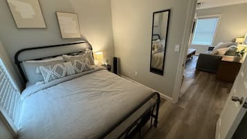 Cozy retreat with a single bed, bedside table, and mirror.