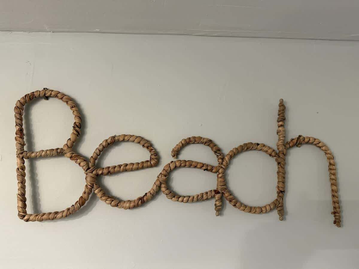 Eine Wand, auf der das Wort 'Beach' aus Seilbuchstaben geschrieben steht.