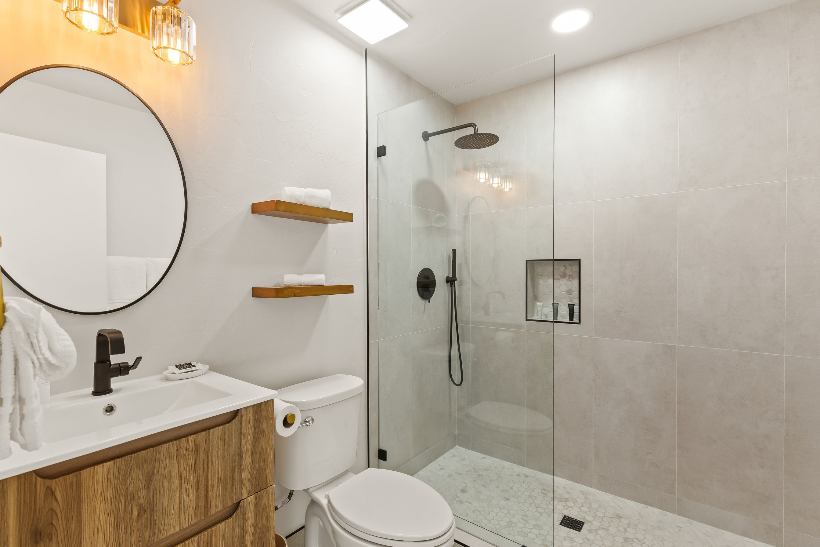 Un baño moderno con inodoro, lavamanos y ducha.