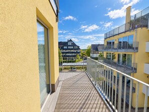 A balcony with a view of neighboring buildings and a clear sky. - Vacation apartment in the mountain resort 3.3.5 - Adventure & wellness with infrared cabin! (Winterberg)
