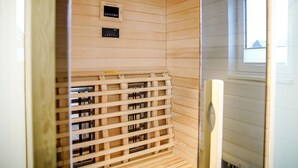 A sauna room with wooden walls, a control panel, and a wooden lattice structure. - Vacation apartment in the mountain resort 3.3.5 - Adventure & wellness with infrared cabin! (Winterberg)