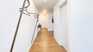 A narrow hallway with wooden flooring, white walls, and a door at the end. - Vacation apartment in the mountain resort 3.3.5 - Adventure & wellness with infrared cabin! (Winterberg)