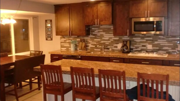 A kitchen with wooden cabinets, a granite countertop, and a built-in microwave.