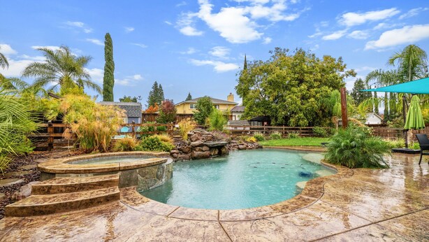 A backyard with a swimming pool, stone steps, and a wooden deck. - Tranquil Retreat: Pool, Spa, Firepit, Peloton, WFH (Orangevale)