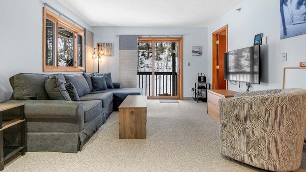 Una sala moderna con un sofá, una mesa de centro y un pouf estampado.