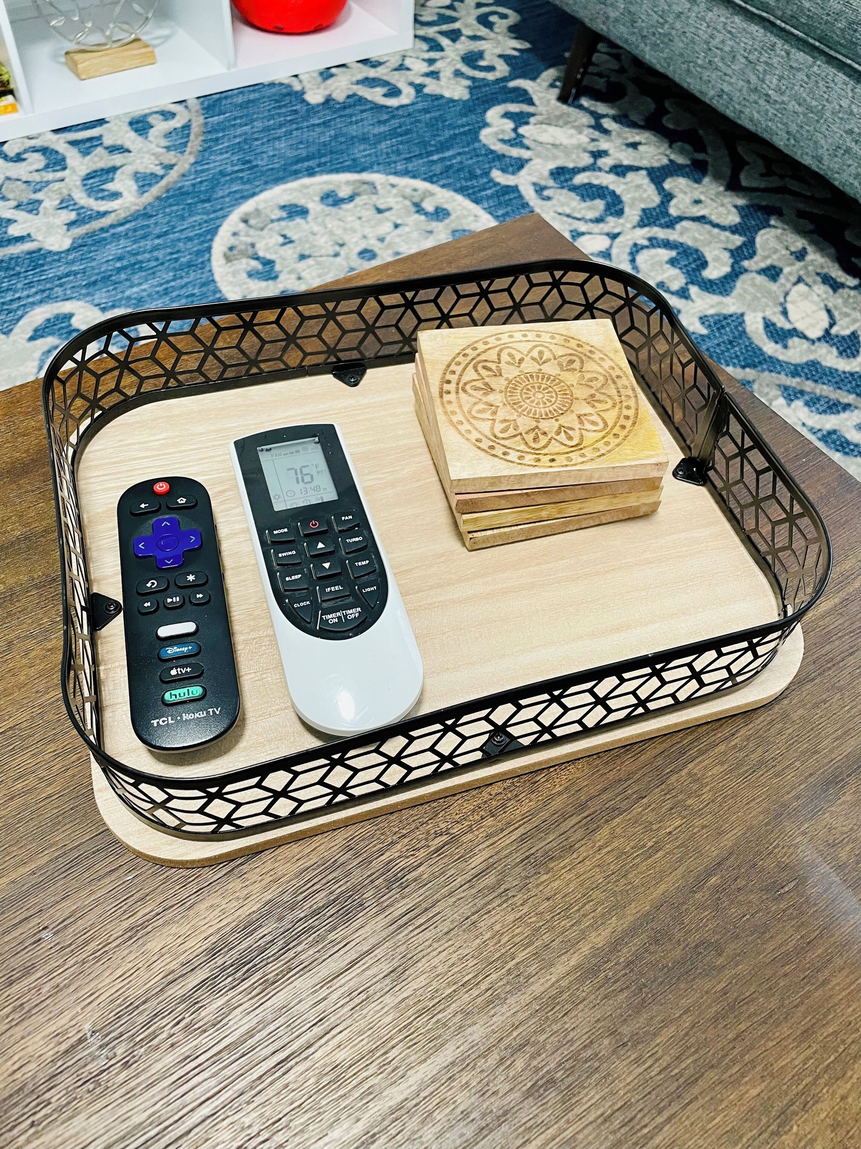 A tray with two remote controls and a stack of wooden blocks.