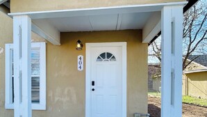 Una casa con una puerta blanca, un buzón y un cartel con el número 404.