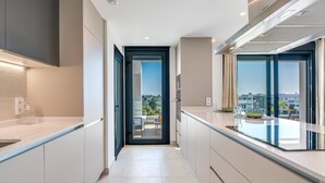 A modern kitchen with a view to the outside. - Newly Built 2 BDRM Modern Oasis w Gym & Pool (Estepona)