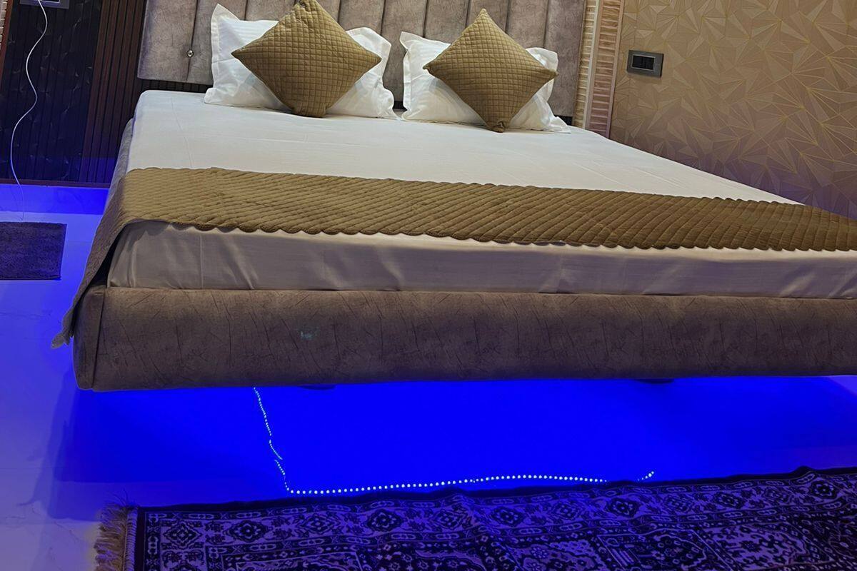 Un dormitorio moderno con una cama grande, aire acondicionado instalado en el techo y una pared con diseño.