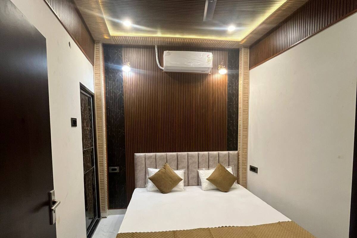 Un dormitorio moderno con cama, paneles de madera, ventilador de techo y equipo de aire acondicionado.