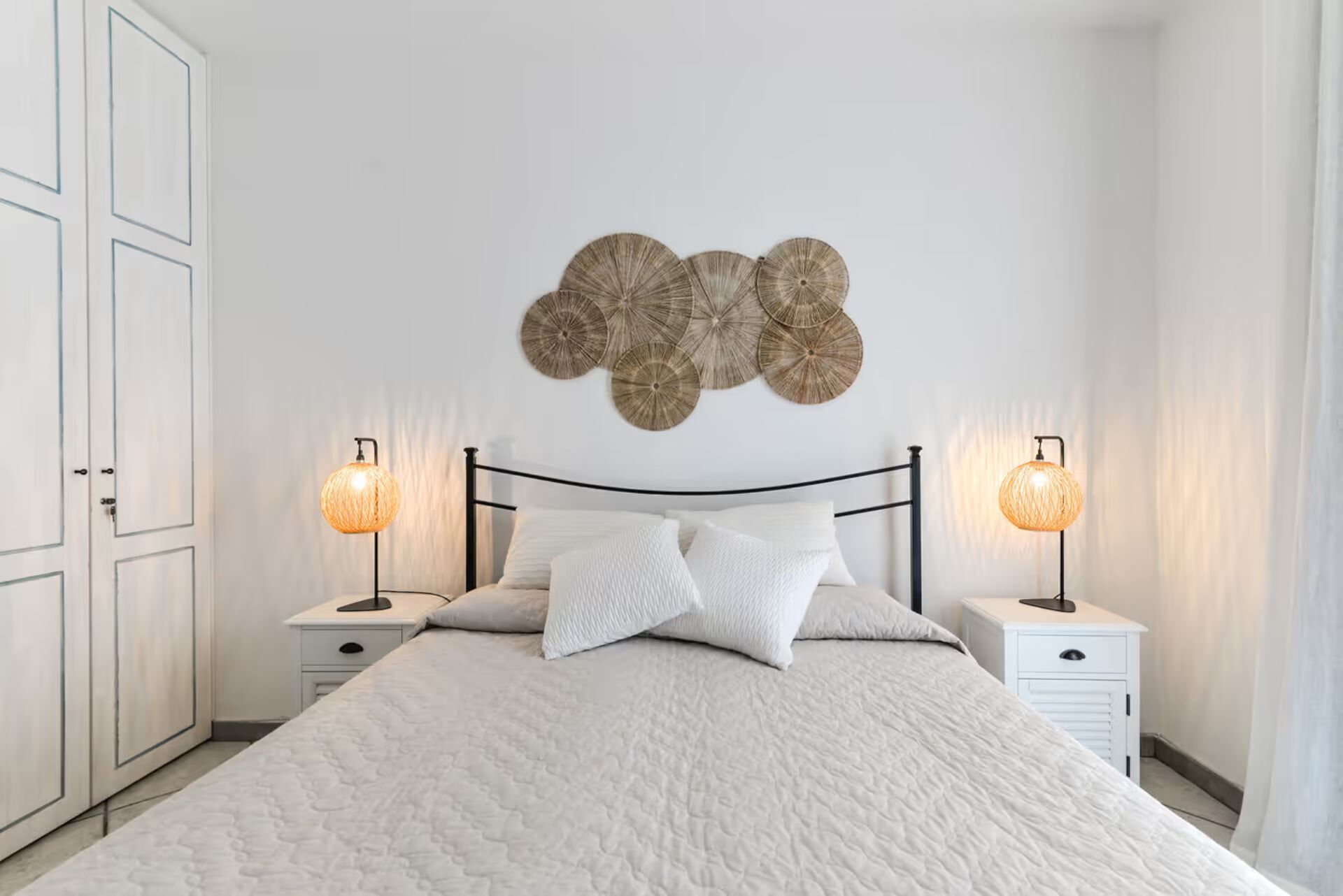 Ein Schlafzimmer mit einem Bett, zwei Nachttischen und einer Wandleuchte.