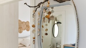 Un miroir surmonté d’une branche et de quelques coquillages.