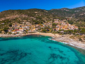 A coastal town with buildings on a hillside overlooking a clear turquoise sea. - APPARTAMENTI DEL SOLE - CASA DEGLI ASINELLI (Campo nell'Elba)