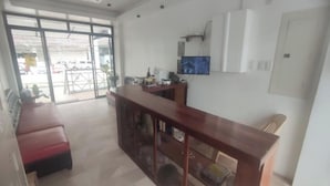 Ein geräumiger Raum mit einem Holzbüro, einer Bank und einem großen Fenster.