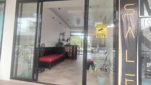 Ein modernes Interieur mit einem roten Sofa, einer Essecke und einem Schild, das Videoüberwachung anzeigt.