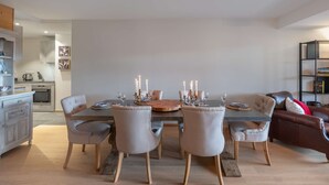 Un comedor con una mesa dispuesta para seis personas, rodeada por seis sillas tapizadas con patas de madera.