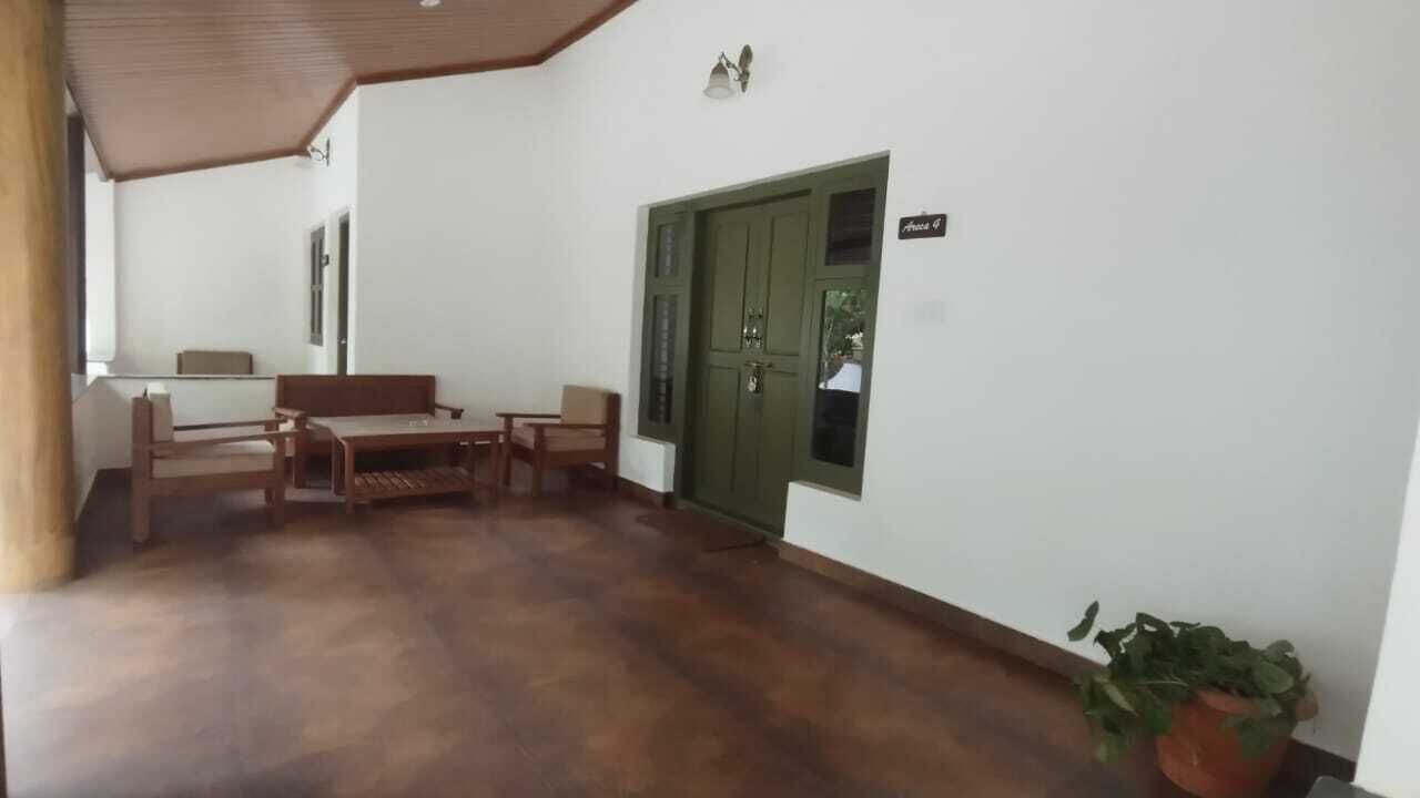 A room with a wooden bench, a small table, and a green door.