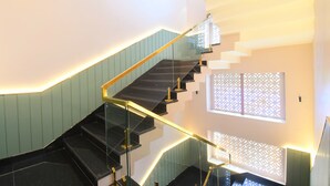 Eine moderne Treppe mit Glastrennläufen und einem geometrischen Wanddesign.