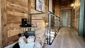 Un intérieur en bois avec une cloison en verre, une machine à café et un panier à chaussures.
