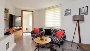 A modern living room with a sofa, coffee table, and a lamp.