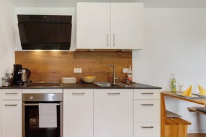 A modern kitchen with white cabinets, a stainless steel oven, a wooden countertop, and a built-in sink. - Apartment 'Staffe' with Mountain View, Private Terrace and Wi-Fi (Bonndorf im Schwarzwald)