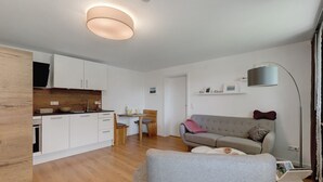 En moderne lejlighed med køkken, spiseplads og opholdsstue.