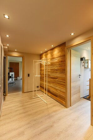 Un intérieur moderne avec des murs lambrissés en bois, une étagère en métal et un plancher en bois.