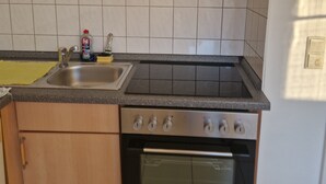 A kitchen with a double sink, a stove, and an oven. - Fantastic Apartment in the Heart of Wedel (Wedel)
